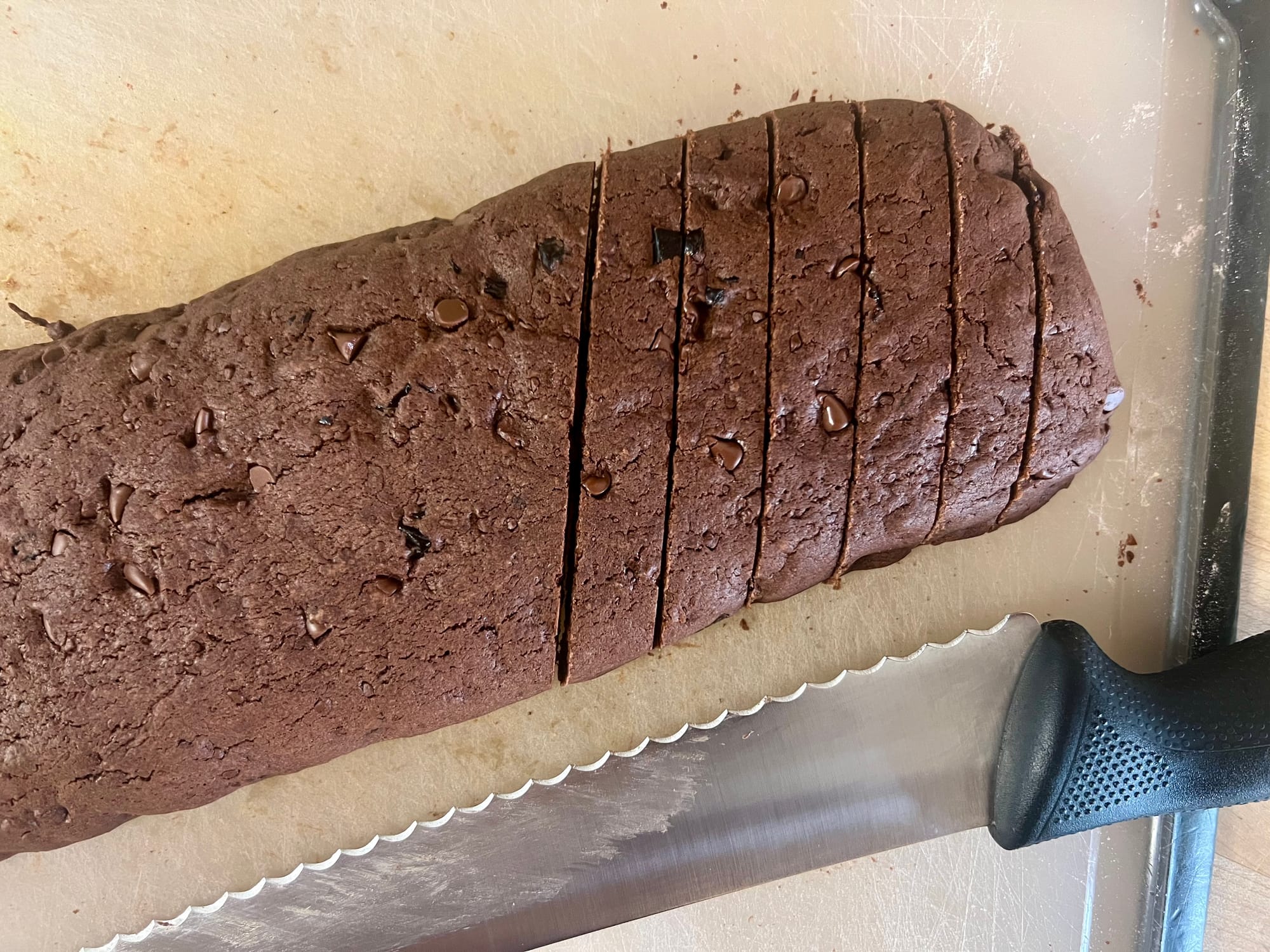 The baked logs are sliced with a serrated knife on a diagonal, about 1/2" wide.