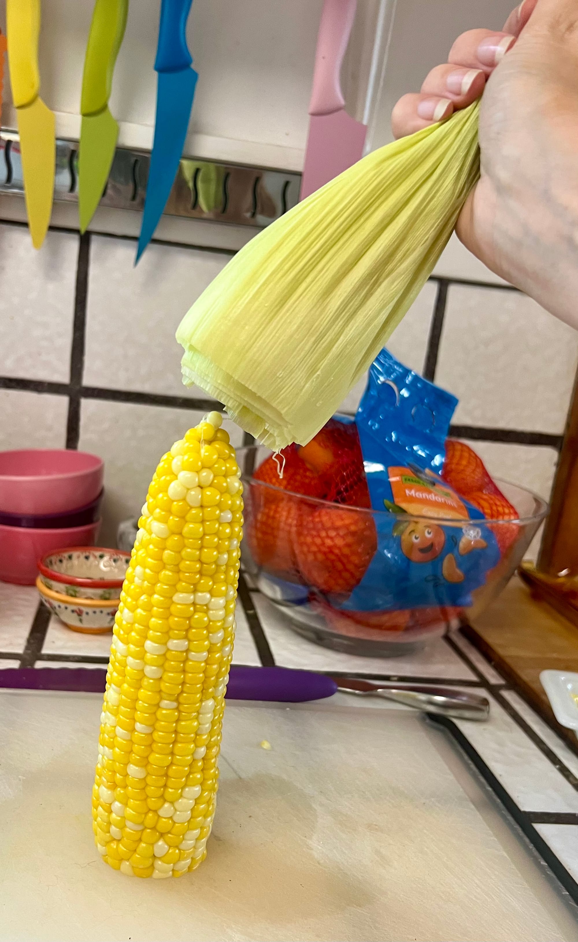 The ear of corn will slide out, leaving a bundle in your hand of leaves and silk, which can go into compost.